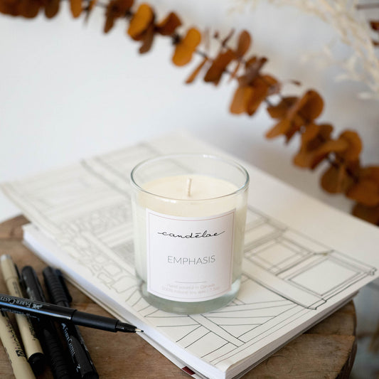 Emphasis scented candle is displayed on a book. It's a perfect candle to focus on work
